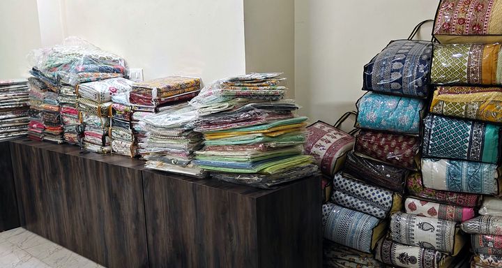 Home linen room with stacks of block print bedsheets and quilts