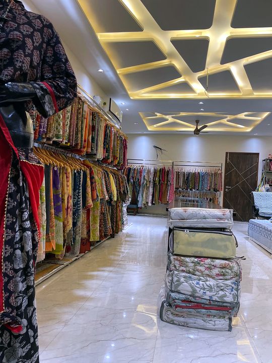 Jaipuri razai quilts stacked in the middle of the store with saree racks